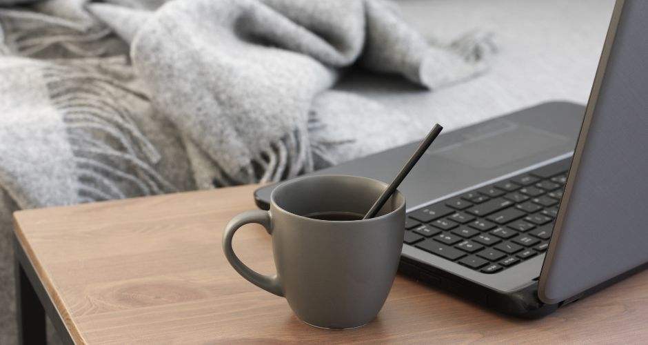 laptop and coffee cup on desk at home